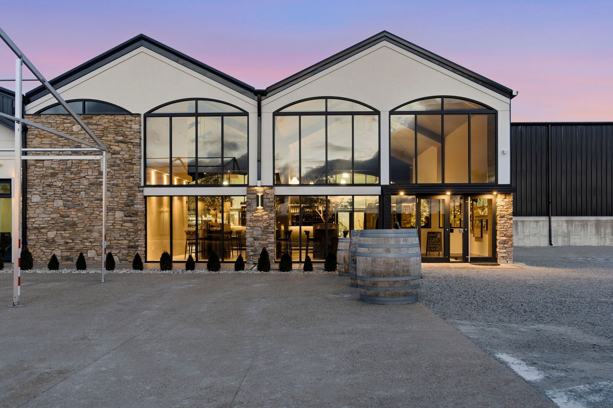The tasting room's arched windows lit at dusk